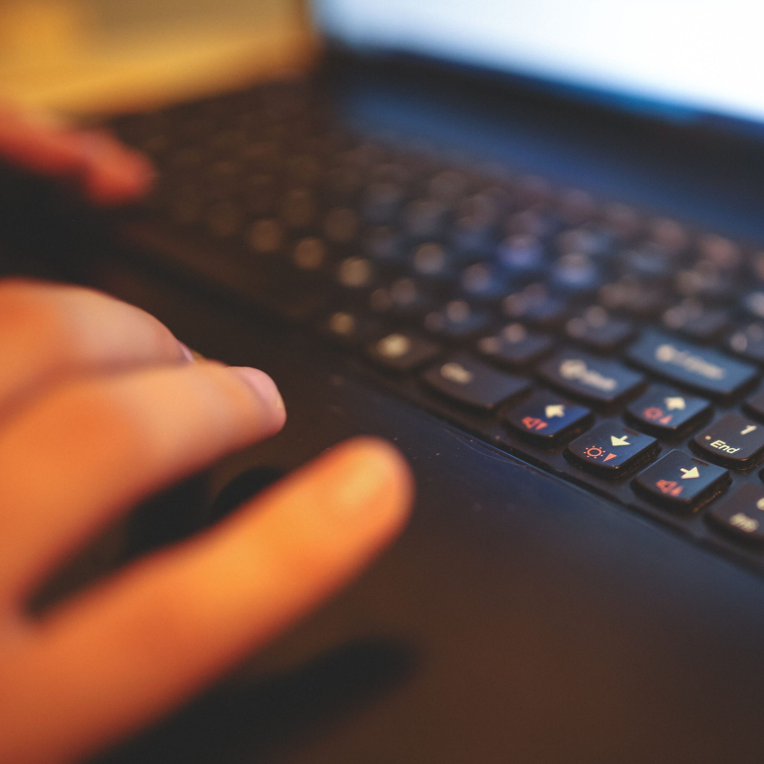 Close view of laptop keyboard, hands getting ready to type.